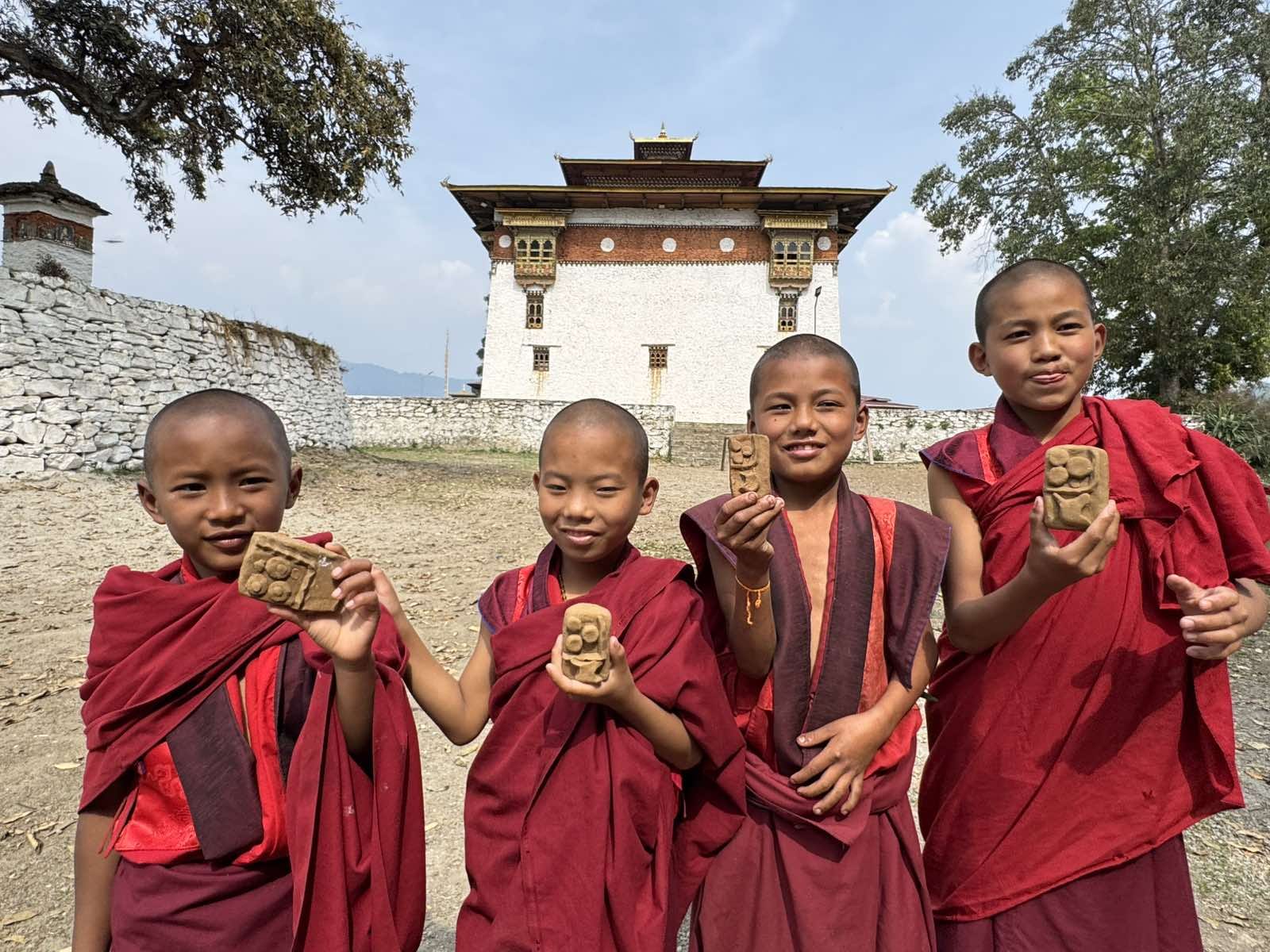 Young monks in traditional red robes at a Bhutanese temple